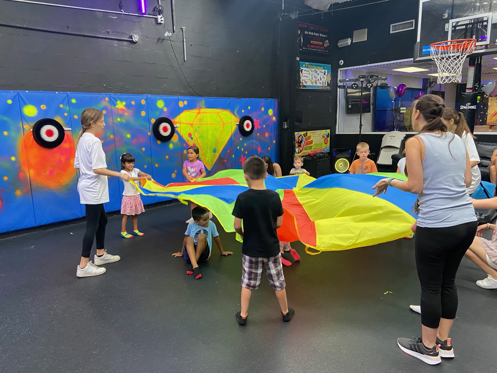 Kids playing the parachute game during a group activity party at All Star Party World